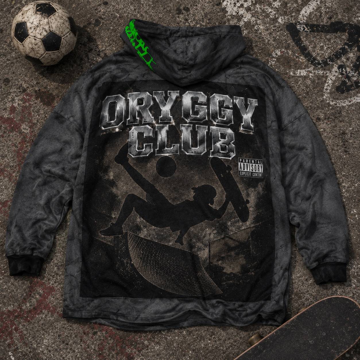 Oryggy Club oversized hooded fleece with skateboarding graphic laid on graffiti-covered concrete, styled with a skateboard and soccer ball in an urban streetwear flat lay.